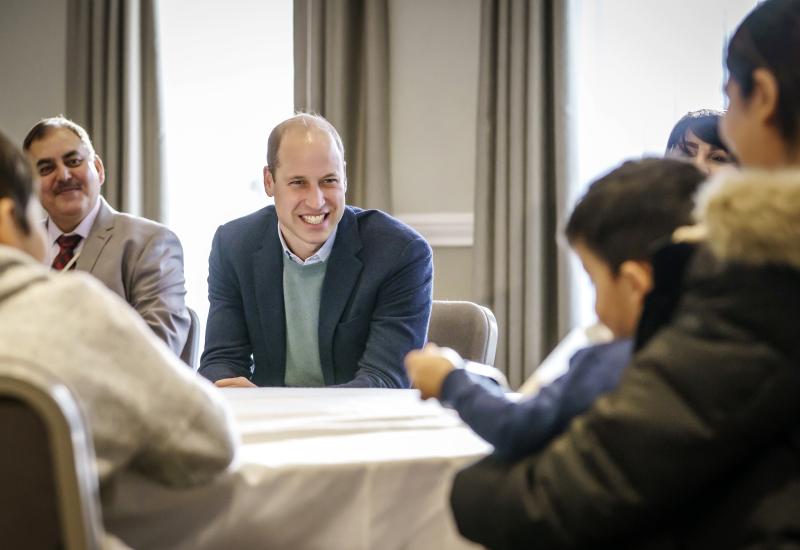 A group of people sitting at a table with the Duke of Cambridge