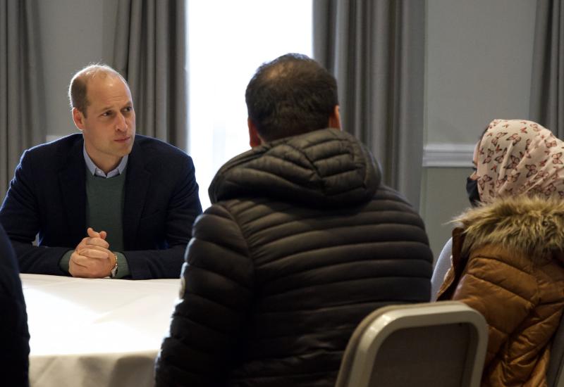 A group of people sitting at a table with the Duke of Cambridge