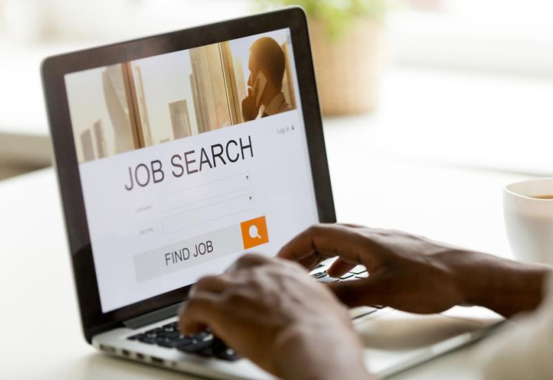 A person carrying looking for a job on a laptop