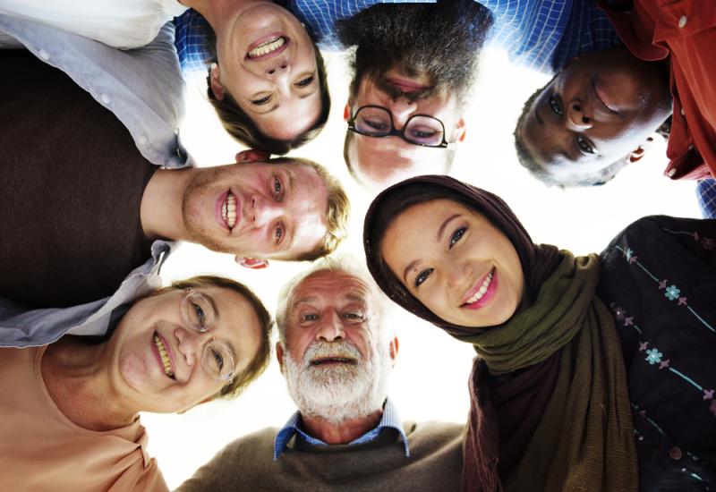 Group of people looking down at a camera.