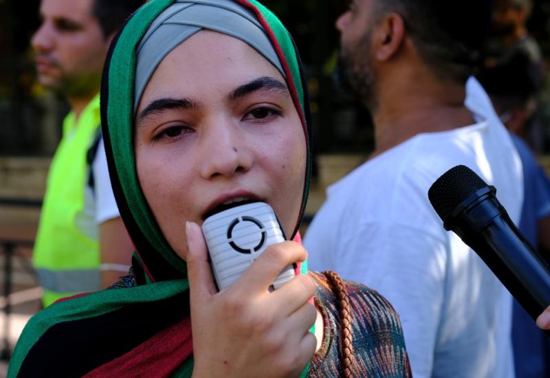 A refugee woman with a loudspeaker