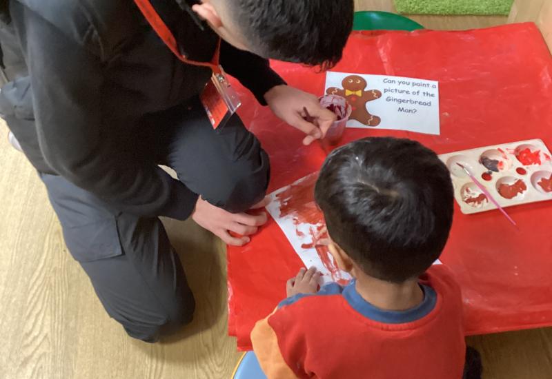 ESOL student and primary school aged child painting