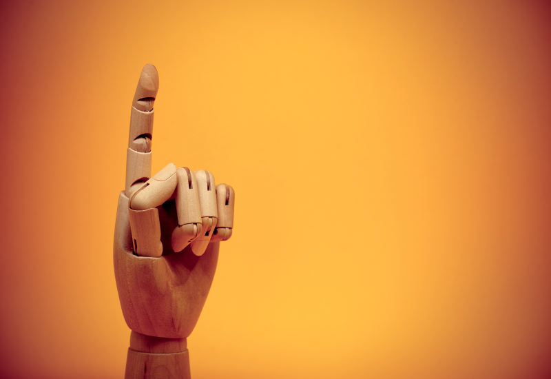 Wooden hand finger pointing upwards