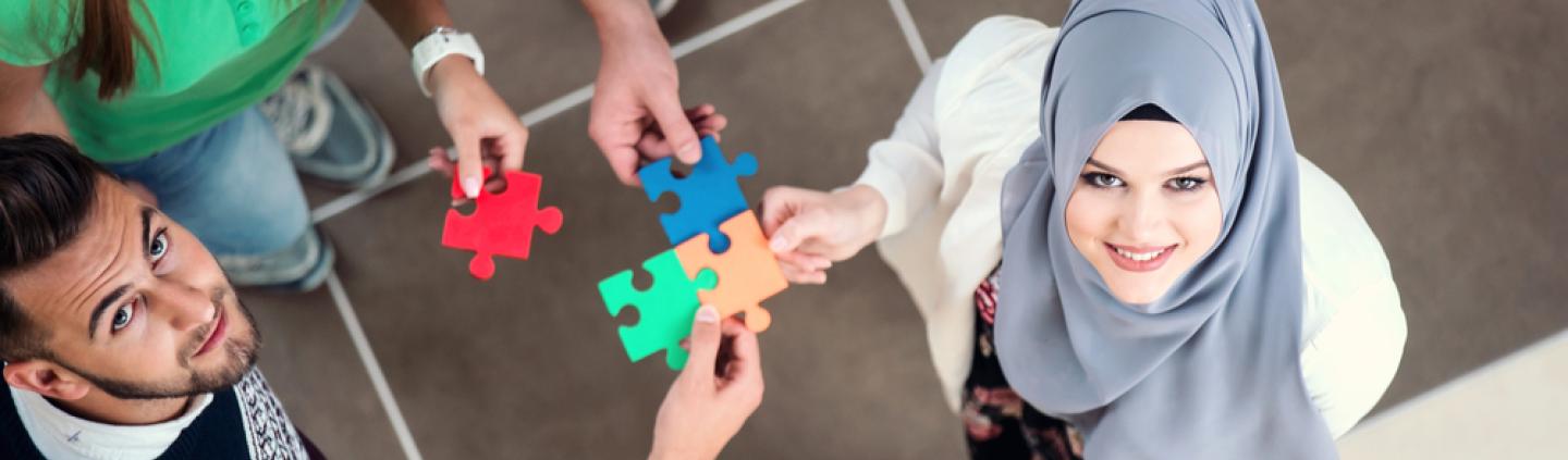 A group of people with jigsaw pieces symbolising integration