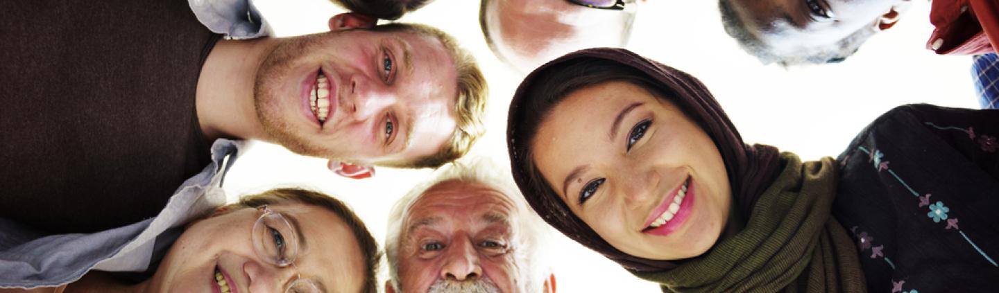 Group of people looking down at a camera.