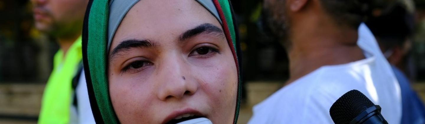 A refugee woman with a loudspeaker