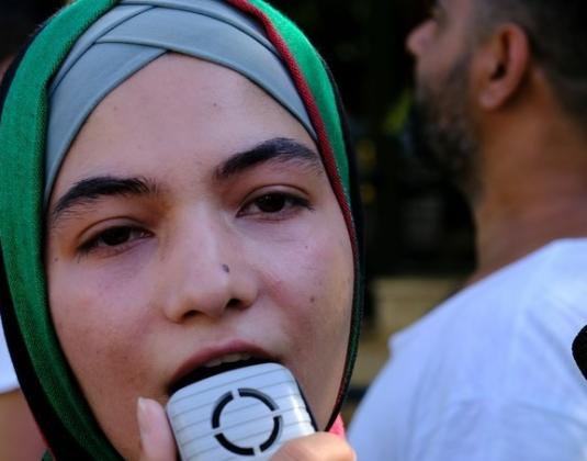 A refugee woman with a loudspeaker