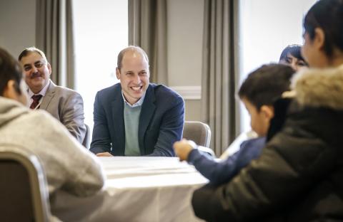 A group of people sitting at a table with the Duke of Cambridge
