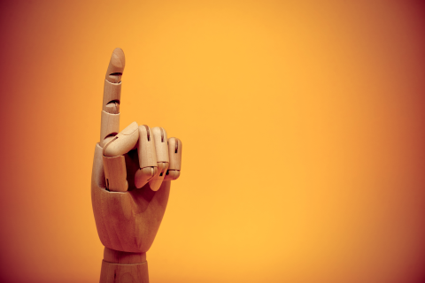 Wooden hand finger pointing upwards