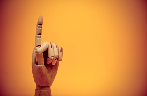 Wooden hand finger pointing upwards