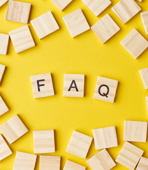 Wooden blocks with the abbreviation FAQ on a yellow background.