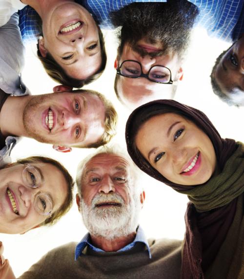 Group of people looking down at a camera.